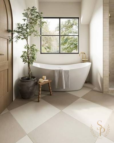 Serene bathroom with freestanding tub, checkerboard limestone floor, and a tall potted tree